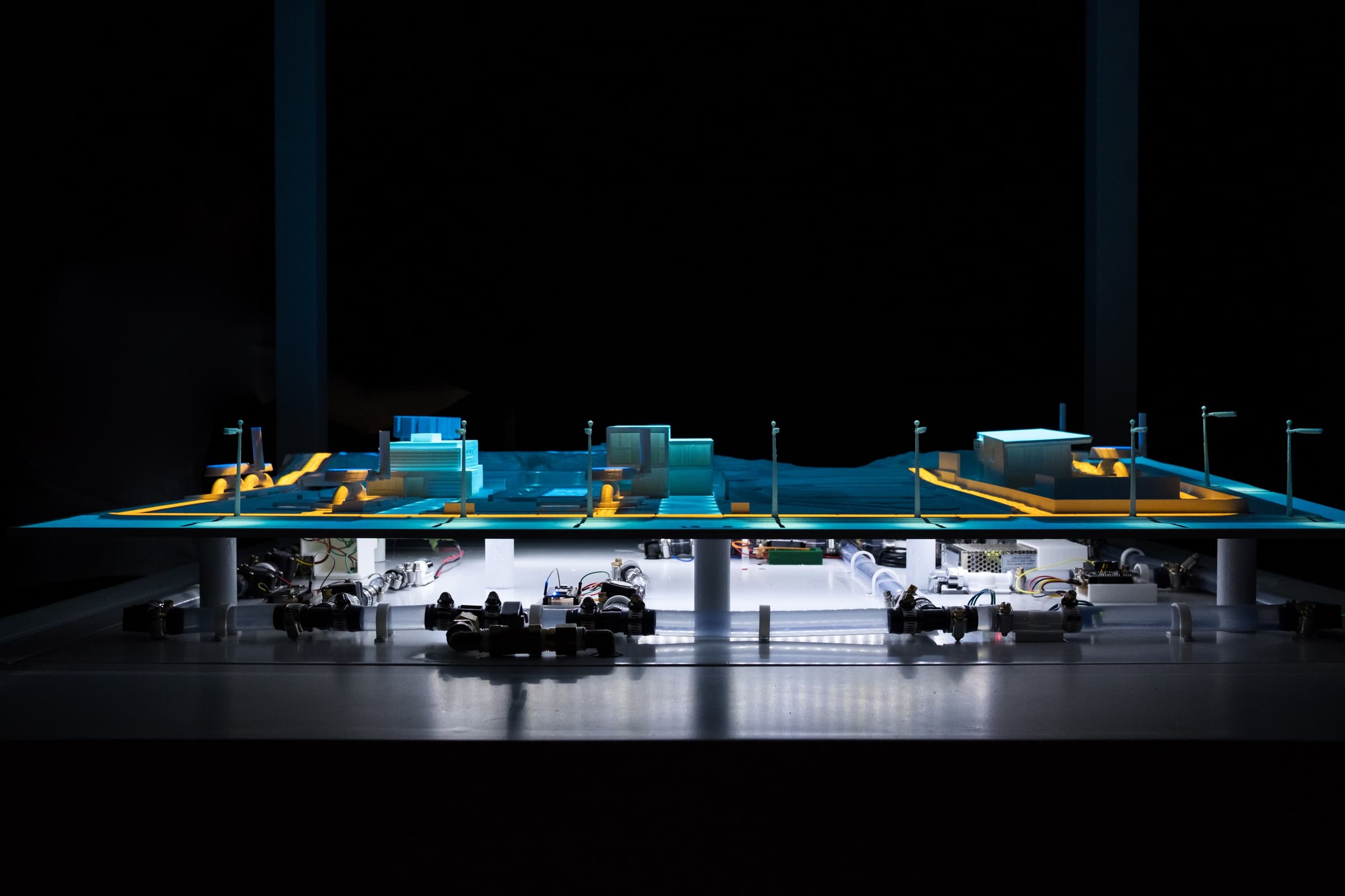 Wide view of the finished H2.0 physical network, with projected blue and orange information above the visible pipes and valves.